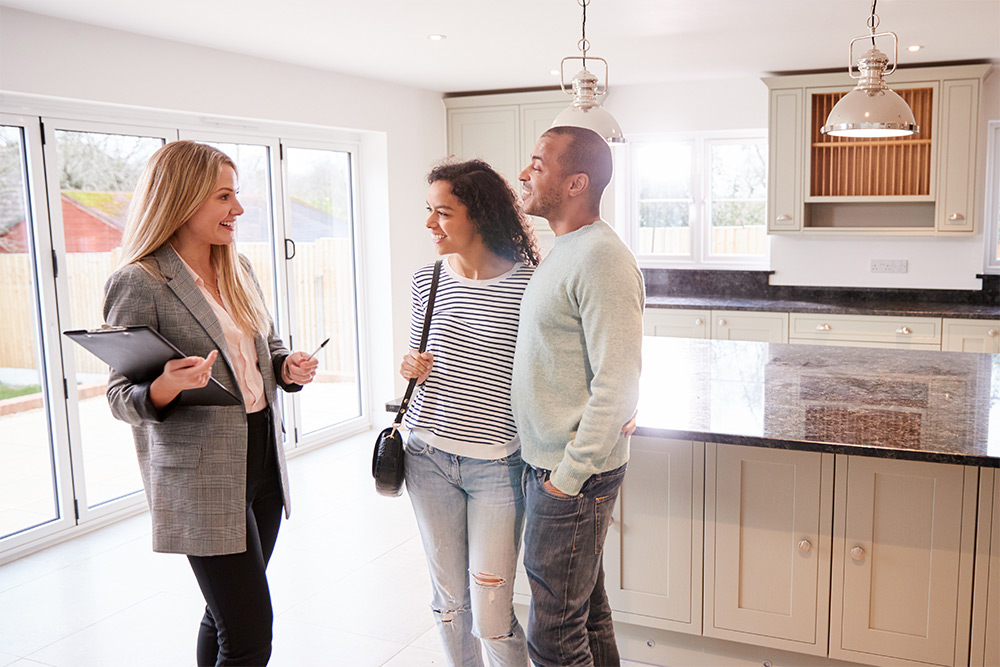 Couple with property investor on house tour